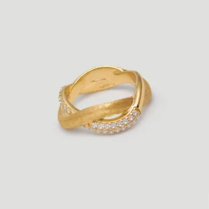 This image shows the "Entwined Dimensions" Intertwined ring, crafted from S925 sterling silver and plated with 18K gold. The ring features a stunning intertwined design, with one part of the band having a smooth, polished finish and the other part adorned with shimmering 5A cubic zirconia stones. The ring is photographed against a clean, light-colored background, and the perspective is slightly tilted to highlight the elegant twist and intricate details of the band. This ring is an exquisite piece of jewelry, perfect for those who appreciate fine craftsmanship and timeless design.