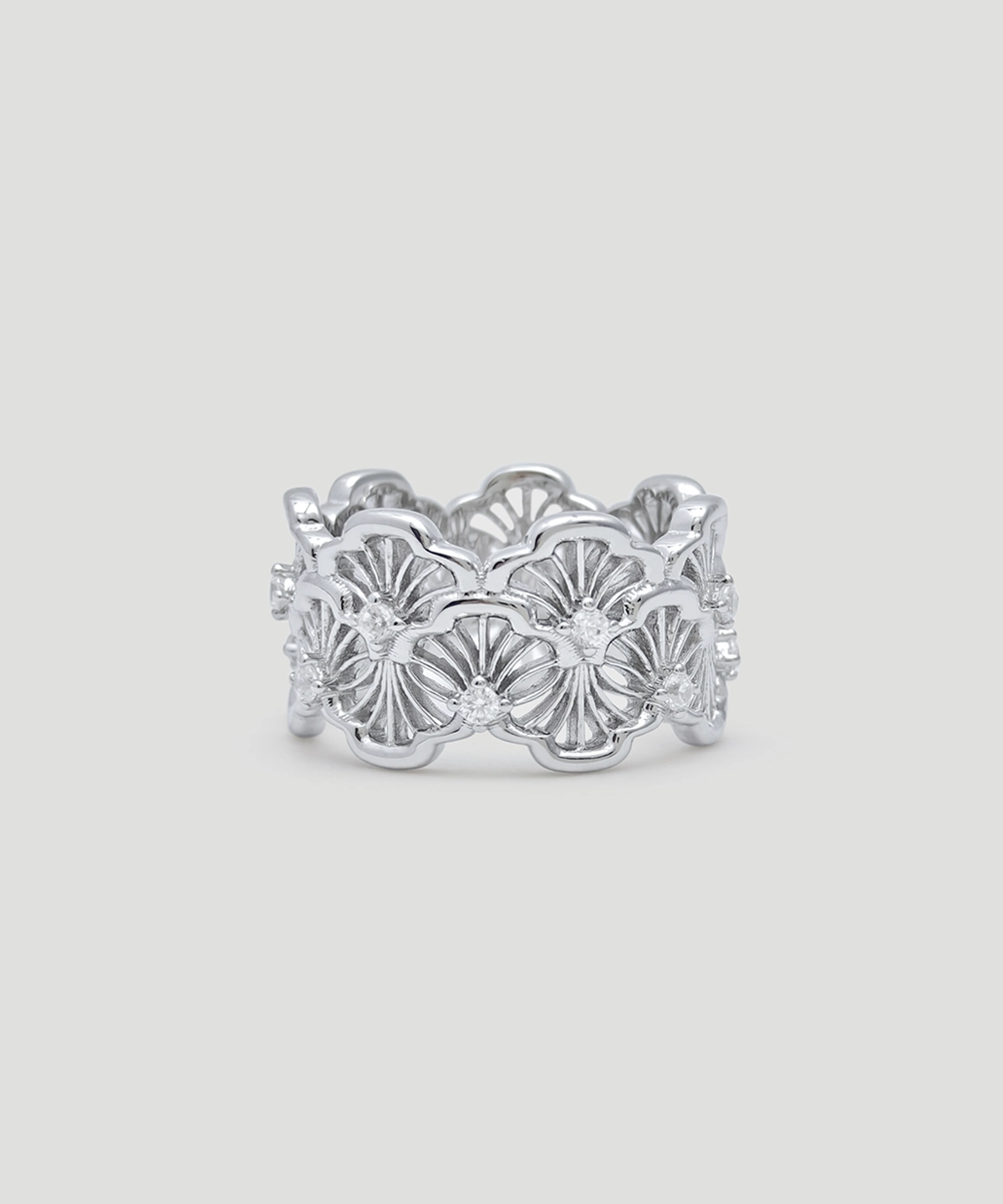This image showcases a silver lace ring. The ring is made of rhodium-plated sterling silver and is set with 5A cubic zirconia stones. The design of the ring is very intricate, with complex lace patterns engraved on its surface, exuding elegance and sophistication. The ring is circular in shape, and the hollow patterns make it look lighter and more transparent. The ring is placed against a light gray background, with clear details that highlight the ring's shine and delicate textures. The overall design is elegant, suitable for various formal occasions, and is a highly artistic accessory.