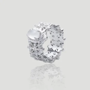 The image shows a beautifully crafted ring named Silver Moon Crown | Sterling Silver Jade Ring. The ring is made of 925 sterling silver and plated with rhodium for enhanced shine and durability. It features intricate designs with 5A cubic zirconia stones embedded throughout the band. The centerpiece of the ring is a smooth, oval-shaped Water foam jade. The ring is displayed in a way that highlights its detailed craftsmanship and the reflective quality of the sterling silver. The inner band of the ring also has a decorative pattern, adding to its overall elegance and appeal.