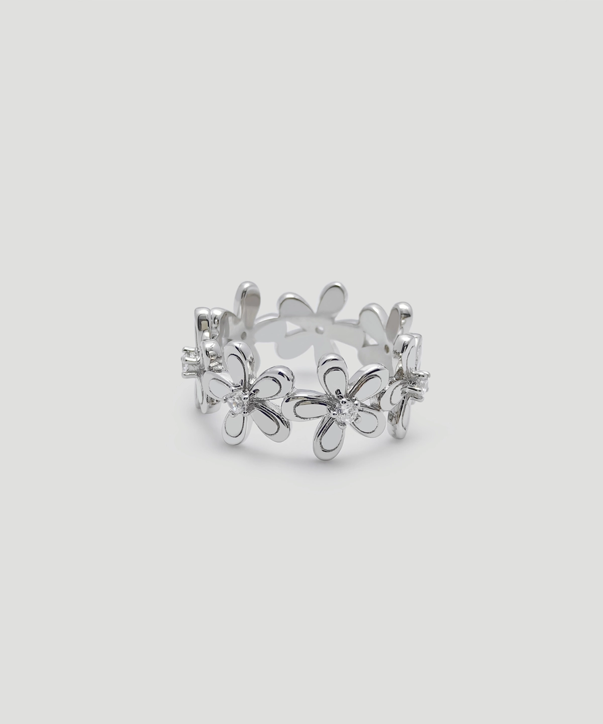 This image showcases the front view of the "Sunshine" silver flower ring, perfectly displaying the ring's overall design and details. The entire ring is made of sterling silver, with a smooth and shiny surface. The main part of the ring features a floral design, with each flower's center studded with sparkling zirconia. The arrangement of the flowers forms a circular pattern, making the ring look like a blooming wreath.