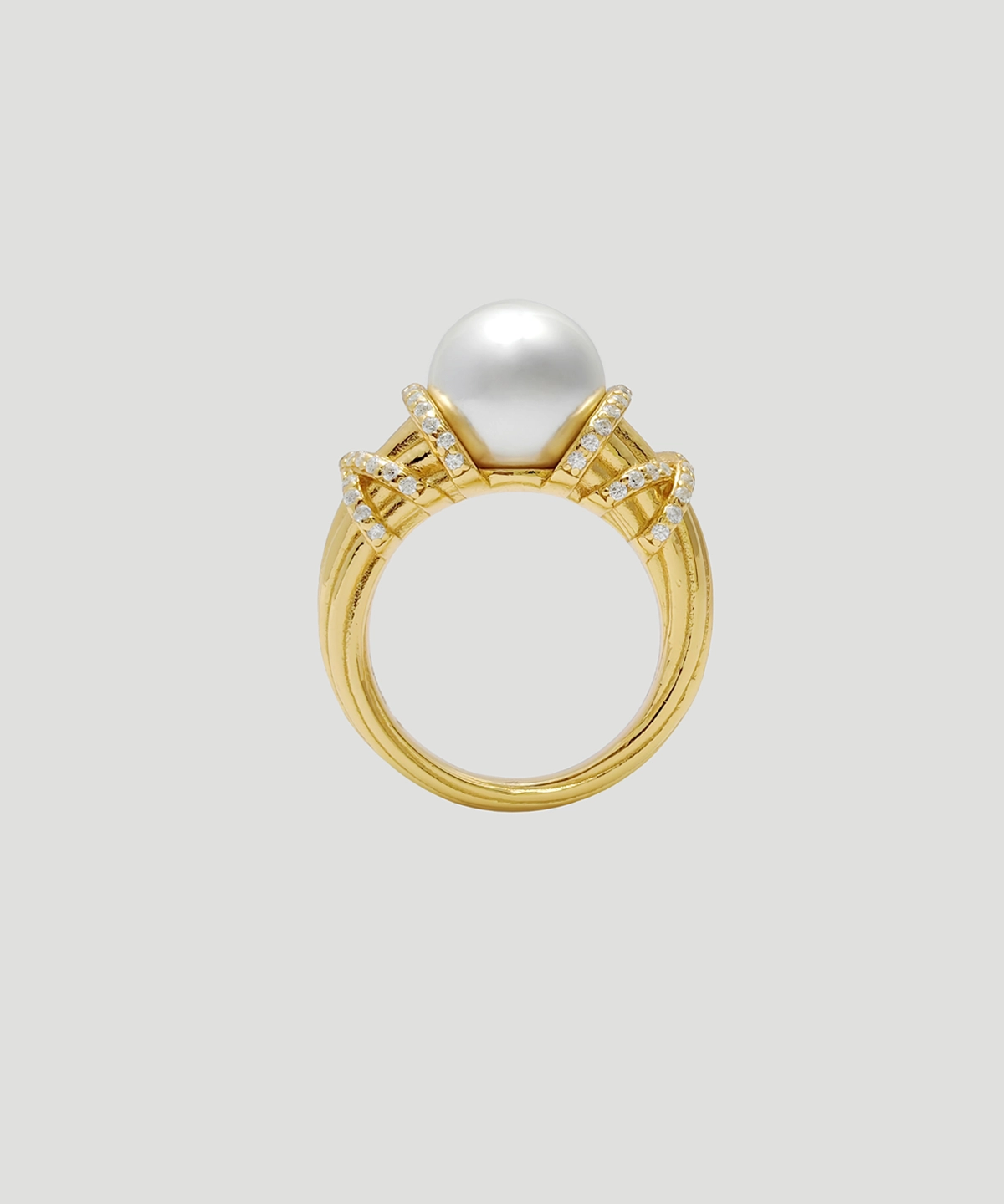 This image showcases a front view of the "Twilight" pearl ring. The ring is made of gold-plated on sterling silver, with a high-luster pearl embedded in the center of the ring face. Surrounding the pearl are several rows of meticulously arranged small diamonds, radiating brilliance. The design of the ring is exquisite, with smooth and elegant curves of the band. The overall design is both modern and classic, making it suitable for various formal occasions.