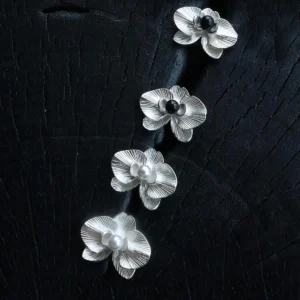 The Butterfly Orchid Earrings—delicate 925 sterling silver floral studs—blend nature-inspired elegance with refined craftsmanship. Each earring features an intricately sculpted orchid, with either a black onyx or white pearl nestled at its center, adding contrast and sophistication. Designed for floral jewelry lovers, these sterling silver studs complement both casual and formal styles. The image presents them against a textured black backdrop, accentuating their fine details—an exquisite choice for those seeking nature-inspired luxury accessories.