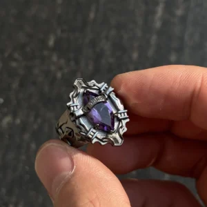The image showcases a stunning sterling silver ring inspired by the anime Katekyo Hitman Reborn! This piece of Handmade Anime Jewelry is meticulously designed as Kyoya Hibari’s Vongola Cloud Ring. The ring features sharp, angular patterns that give it a bold and gothic look. At its center is a brilliant natural amethyst gemstone, radiating a deep purple hue that symbolizes the Cloud Flame’s power and elegance. The polished sterling silver band perfectly complements the gemstone’s vibrant color. Above the gemstone, the word "VONGOLA" is engraved, emphasizing its connection to the anime and its significance as a Katekyo Hitman Reborn Ring. The ring’s intricate craftsmanship and attention to detail make it an exceptional piece for fans and collectors of Vongola Rings.