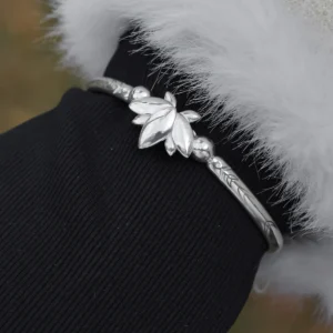 The Lazesoul Handmade Anime Jewelry — 999 Pure Silver Open Adjustable Bangle, Frieren: Beyond Journey's End Mirror Lotus Bracelet, shines in its Polished Finish. The image captures it worn on a wrist, elegantly framed by a black sleeve and a soft white cuff, enhancing its refined brilliance. The sculpted lotus centerpiece and intricate engravings reflect anime artistry and fine craftsmanship. Designed for collectors and fans, this adjustable silver bangle adds a sophisticated touch to daily wear or cosplay. Set against an outdoor backdrop, the bracelet’s radiant surface gleams naturally, emphasizing purity and elegance—an essential piece for anime-inspired luxury accessories.