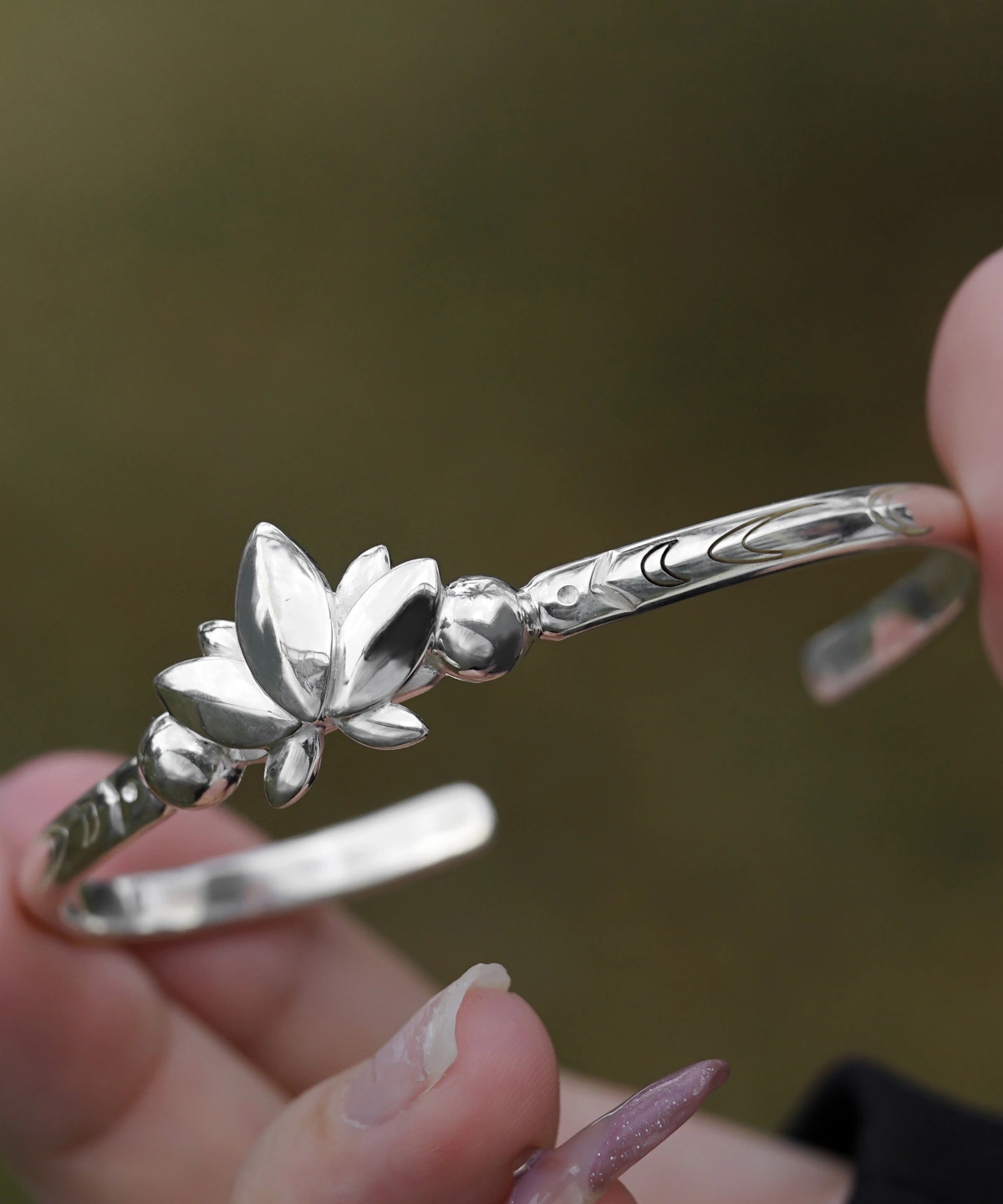 The Lazesoul Handmade Anime Jewelry — 999 Pure Silver Open Adjustable Bangle, inspired by Frieren: Beyond Journey's End, embodies elegance and artistry. The bracelet features a sculpted lotus motif, symbolizing wisdom and renewal, with intricate engravings accentuating its refined craftsmanship. Designed for anime collectors and jewelry enthusiasts, its adjustable open design ensures a comfortable fit. Set against a soft-focus backdrop, the image highlights the bangle’s polished texture, emphasizing its premium quality. Ideal for cosplay or daily wear, this anime-inspired luxury accessory adds sophistication to any look.