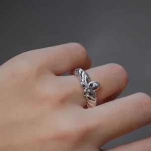 The Mirror Lotus Ring from Lazesoul Handmade Anime Jewelry is a 999 pure silver adjustable ring, inspired by Frieren: Beyond Journey’s End. The image captures the ring elegantly worn on a hand, showcasing its intricate lotus flower and leaf details. The polished silver finish reflects light beautifully, enhancing its premium craftsmanship. The adjustable open-band design ensures a perfect fit, making it ideal for anime collectors and jewelry lovers. Set against a dark background, the luminous silver ring stands out, emphasizing its artistic elegance. A timeless accessory for daily wear or special occasions.
