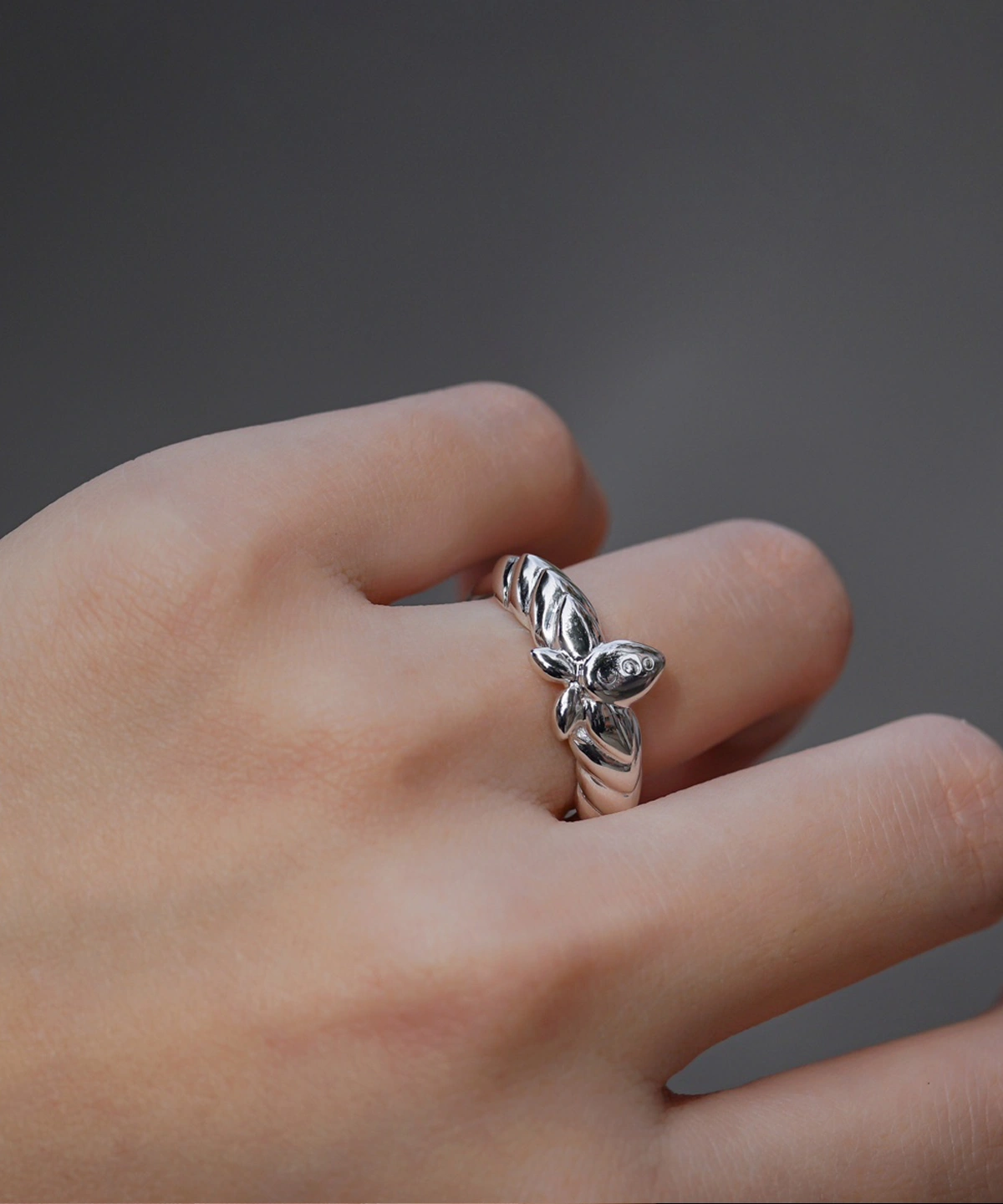 The Mirror Lotus Ring from Lazesoul Handmade Anime Jewelry is a 999 pure silver adjustable ring, inspired by Frieren: Beyond Journey’s End. The image captures the ring elegantly worn on a hand, showcasing its intricate lotus flower and leaf details. The polished silver finish reflects light beautifully, enhancing its premium craftsmanship. The adjustable open-band design ensures a perfect fit, making it ideal for anime collectors and jewelry lovers. Set against a dark background, the luminous silver ring stands out, emphasizing its artistic elegance. A timeless accessory for daily wear or special occasions.