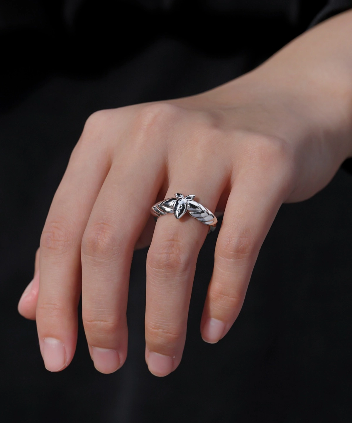 The Mirror Lotus Ring from Lazesoul Handmade Anime Jewelry is a 999 pure silver adjustable ring, inspired by Frieren: Beyond Journey’s End. The image captures the ring elegantly worn on a hand, showcasing its intricate lotus flower and leaf details. The polished silver finish reflects light beautifully, enhancing its premium craftsmanship. The adjustable open-band design ensures a perfect fit, making it ideal for anime collectors and jewelry lovers. Set against a dark background, the luminous silver ring stands out, emphasizing its artistic elegance. A timeless accessory for daily wear or special occasions.
