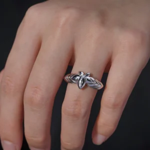 The Mirror Lotus Ring from Lazesoul Handmade Anime Jewelry is a 999 pure silver adjustable ring, inspired by Frieren: Beyond Journey’s End. The image captures the ring elegantly worn on a hand, showcasing its intricate lotus flower and leaf details. The polished silver finish reflects light beautifully, enhancing its premium craftsmanship. The adjustable open-band design ensures a perfect fit, making it ideal for anime collectors and jewelry lovers. Set against a dark background, the luminous silver ring stands out, emphasizing its artistic elegance. A timeless accessory for daily wear or special occasions.