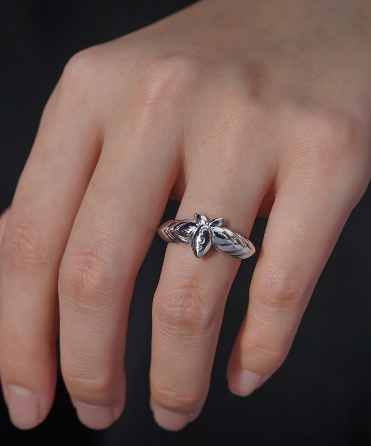 The Mirror Lotus Ring from Lazesoul Handmade Anime Jewelry is a 999 pure silver adjustable ring, inspired by Frieren: Beyond Journey’s End. The image captures the ring elegantly worn on a hand, showcasing its intricate lotus flower and leaf details. The polished silver finish reflects light beautifully, enhancing its premium craftsmanship. The adjustable open-band design ensures a perfect fit, making it ideal for anime collectors and jewelry lovers. Set against a dark background, the luminous silver ring stands out, emphasizing its artistic elegance. A timeless accessory for daily wear or special occasions.