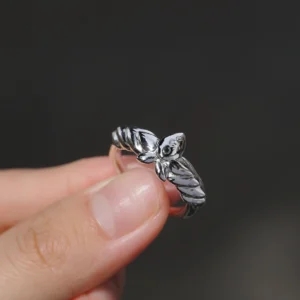A close-up view of the Lazesoul Handmade Mirror Lotus Ring reveals its exquisite detail—crafted from 999 pure silver with a bold, sculptural lotus design inspired by Frieren: Beyond Journey’s End. The open adjustable band and anime-style motif make it a perfect accessory for fans of fantasy, artful jewelry, and storytelling through design.