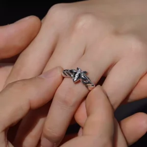 A close-up captures a tender moment as one hand gently slips the Lazesoul Handmade Mirror Lotus Ring onto another. Crafted from 999 pure silver, this open adjustable ring draws inspiration from Frieren: Beyond Journey’s End, featuring a stylized lotus motif with anime charm. Ideal for fans of fantasy jewelry and meaningful gifts.