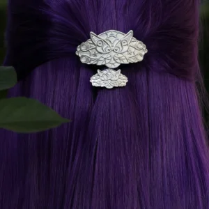 Close-up of the Elven Fern Hair Clip, a handmade 925 sterling silver accessory, featuring a distinctive asymmetrical design—one larger fern leaf and one smaller fern leaf. The detailed craftsmanship enhances the fantasy aesthetic, nestled in vibrant purple hair.
