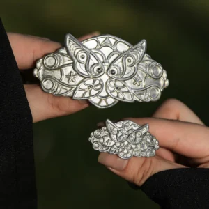 Two hands elegantly holding a pair of Elven Fern Hair Clips—one larger and one smaller—handmade in 925 Sterling Silver. The intricate fern-inspired design highlights an ethereal, nature-inspired aesthetic, with the size variation adding versatility to styling.