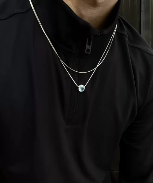 A sterling silver blue eyes necklace inspired by Gojo Satoru’s Six Eyes. The delicate round pendant features a textured design, subtly reflecting light for an eye-catching effect. A brilliant natural topaz sits at the center, evoking the character’s striking gaze. The pendant hangs elegantly on a fine silver chain, complementing both casual and formal looks. Perfect for anime enthusiasts and lovers of sophisticated, artistic jewelry.