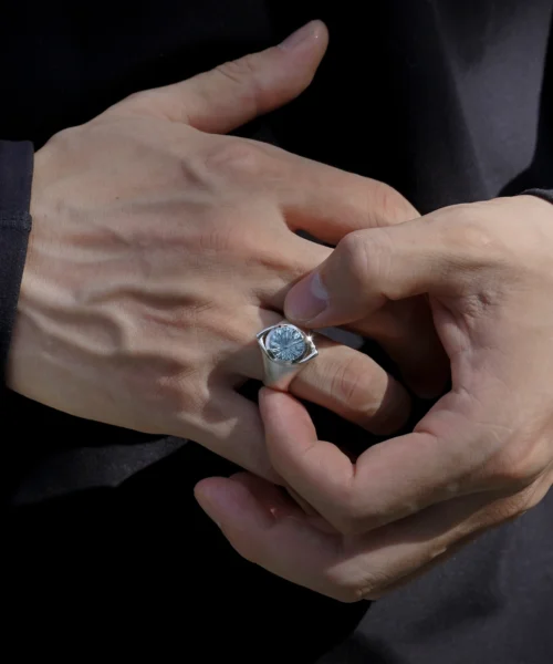 Close-up of hands holding a Six Eyes Ring in Sterling Silver with Natural Topaz, showcasing intricate design inspired by Gojo Satoru from anime.