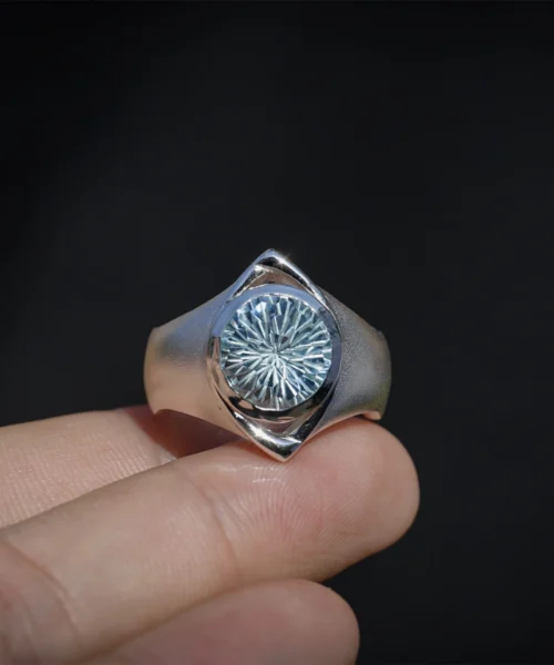 Six Eyes Ring in Sterling Silver with Natural Topaz, resting elegantly on an open palm against a dark backdrop, highlighting its intricate craftsmanship.