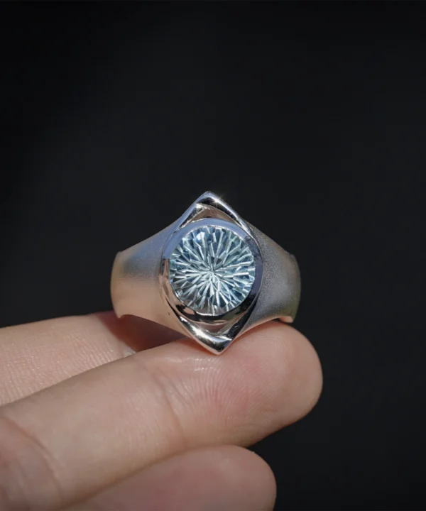 Six Eyes Ring in Sterling Silver with Natural Topaz, resting elegantly on an open palm against a dark backdrop, highlighting its intricate craftsmanship.
