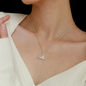 A person wearing the Snow Mountain Necklace with a 999 Pure Silver Pendant, featuring a triangular, snow-capped mountain design. The fine silver chain complements the pendant’s elegant craftsmanship. The person is dressed in a light-colored, textured top, providing a subtle background to highlight the necklace’s details.