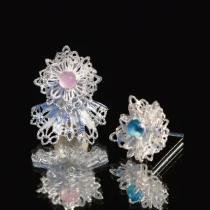 Snowflake Earrings | Elegant 925 Sterling Silver Lace Stud Earrings featuring an intricate snowflake-inspired filigree design. One earring is accented with a delicate pink gemstone, while the other showcases a serene blue gemstone, adding a harmonious touch of color. Their polished silver finish enhances the intricate craftsmanship, making them a timeless winter-inspired accessory.