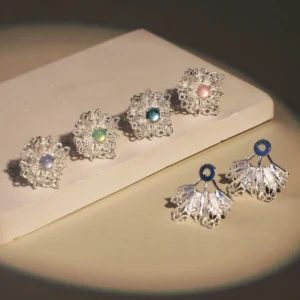 Snowflake Earrings displayed on a neutral-toned surface. These 925 Sterling Silver Lace Stud Earrings feature intricate snowflake-inspired lace patterns, paired with matching fan-shaped drop elements adorned with vibrant gemstone accents in shades of blue, green, and pink.