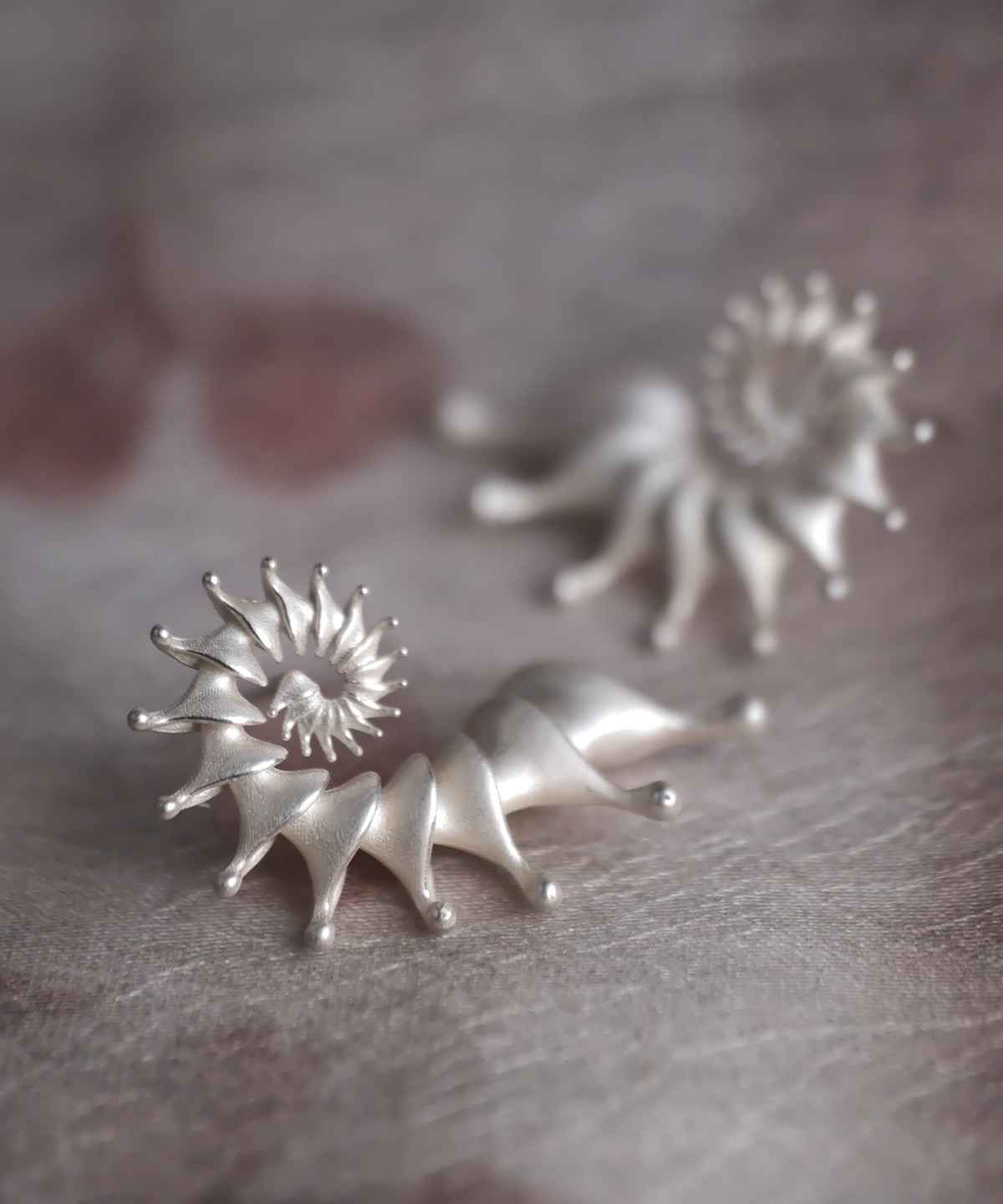 Close-up image of Spiral Earrings crafted from S925 Sterling Silver. The designer ear cuffs feature a sleek spiral design with pointed tips, showcasing modern elegance and intricate craftsmanship.