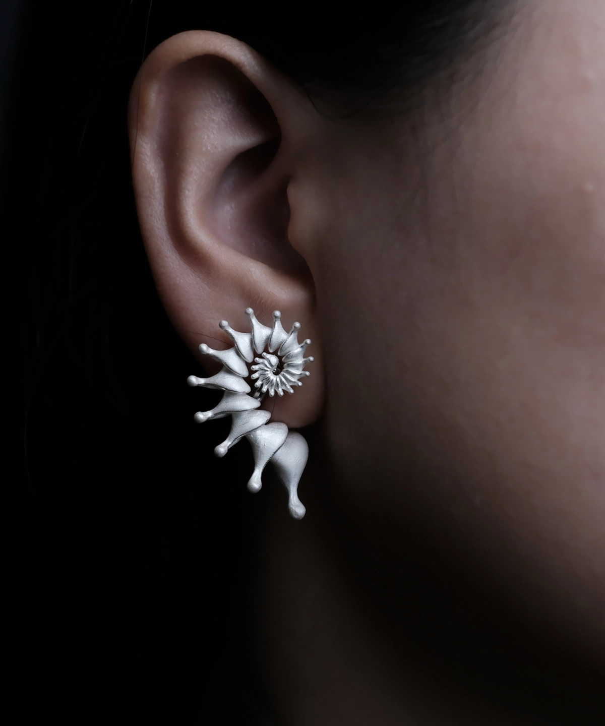 Close-up of a woman's right ear wearing a Spiral Earrings piece—a Designer Ear Cuff made from S925 Sterling Silver. The ear cuff delicately wraps around the ear’s curve, featuring an elegant spiral design with pointed accents.