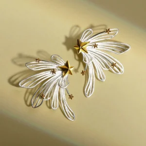 A celestial-inspired jewelry piece, the Star Trail | 925 Sterling Silver Star Stud Earrings & Ear Cuffs feature a striking gold star with delicate silver trails, creating the illusion of a shooting star. Adorned with smaller gold stars along its elegant arc, this design beautifully hugs the ear. The close-up image captures its intricate craftsmanship, with a gently touching hand adding a graceful touch. Made with 925 sterling silver, this accessory blends sophistication with a dreamy cosmic allure. Perfect for those who love starry elegance.