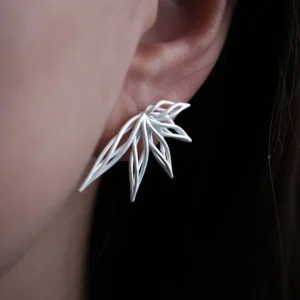 Close-up of an ear adorned with Dancing Petals-Organic Sterling Silver Statement Earrings, showcasing delicate petal-like silverwork.