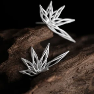 Organic sterling silver statement earrings featuring a flowing petal-inspired design, elegantly displayed on a rustic wooden surface.