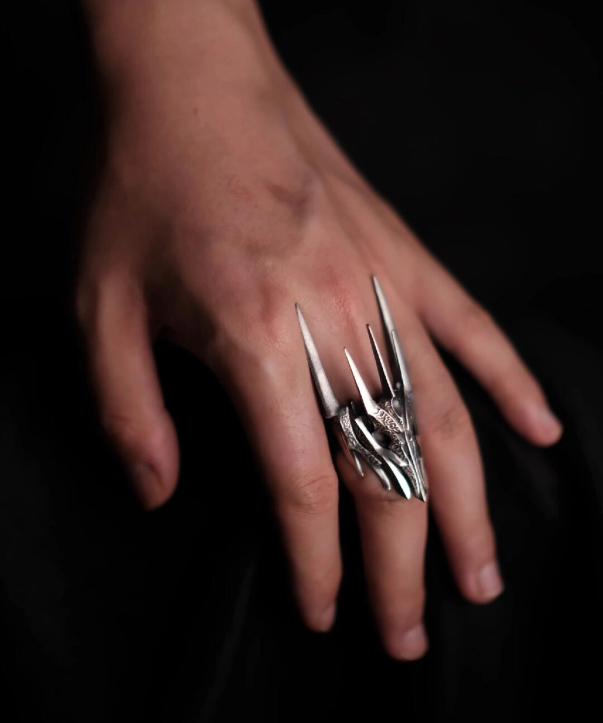 A close-up view of a hand wearing the Dark Lord Ring for Men, a 925 Sterling Silver Gothic Armor Ring inspired by Sauron from The Lord of the Rings.