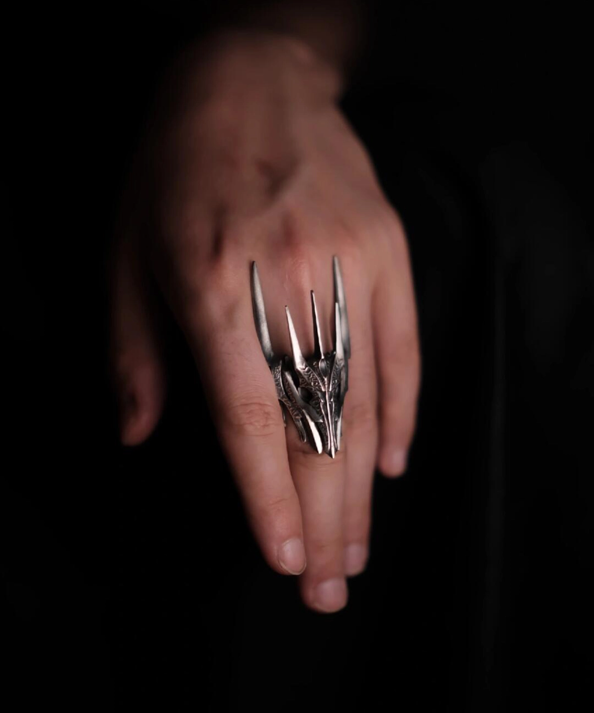 A close-up view of a hand wearing the Dark Lord Ring for Men, a 925 Sterling Silver Gothic Armor Ring inspired by Sauron from The Lord of the Rings.
