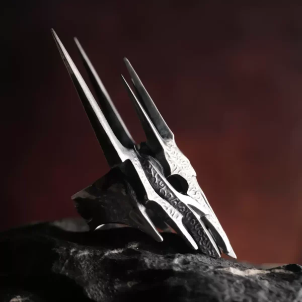 Side view of the Dark Lord Ring for Men, a 925 Sterling Silver Gothic Armor Ring inspired by Sauron from The Lord of the Rings, resting on a dark rock.