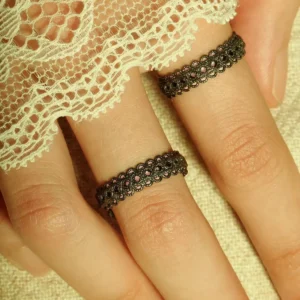 A close-up of two fingers wearing intricately designed Lace Rings crafted from S925 sterling silver. These adjustable rings feature a detailed vintage lace pattern, creating an elegant and artistic aesthetic. The fingers are partially draped in delicate white lace fabric, enhancing the refined look.