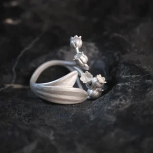 A close-up image of a Lily of the Valley Ring made from S925 sterling silver. The ring features delicate, handcrafted lily of the valley flowers and an adjustable open design.