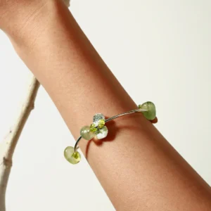 A close-up of the Prelude Summer natural peridot bracelet in sterling silver worn on a wrist, featuring handcrafted green prehnite and peridot stones from Lazesoul. Elegant and minimal jewelry for summer styling. Peridot Bracelet, handmade jewelry.