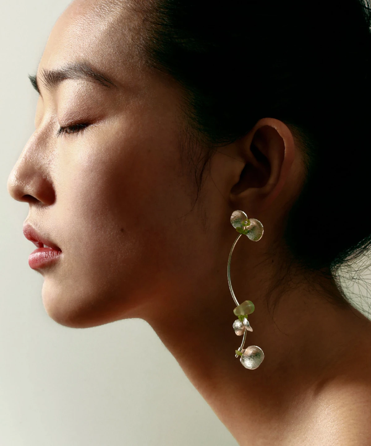 A close-up of a model wearing Lazesoul’s handmade Prelude Summer earrings in S925 sterling silver, featuring elegant curves with natural prehnite and peridot gemstones—delicate, stylish Peridot Earrings for summer wear.