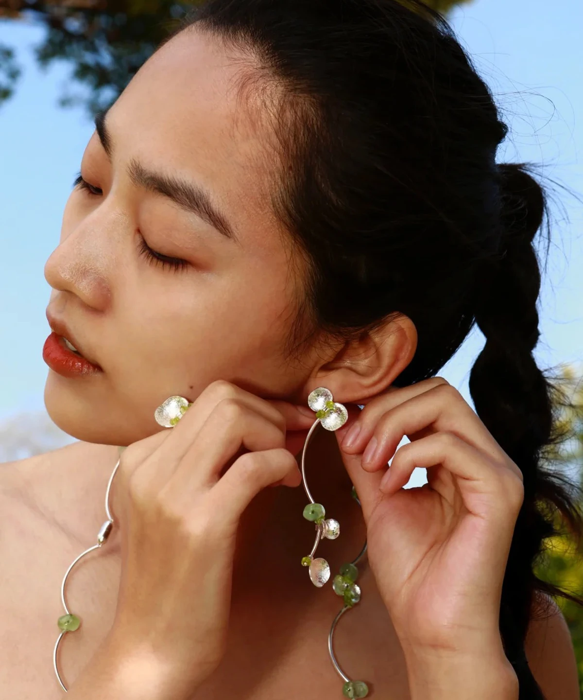 Close-up of a model wearing Lazesoul’s handmade Peridot Earrings and matching necklace from the Prelude Summer collection, crafted with S925 sterling silver, natural Prehnite, and Peridot gemstones.