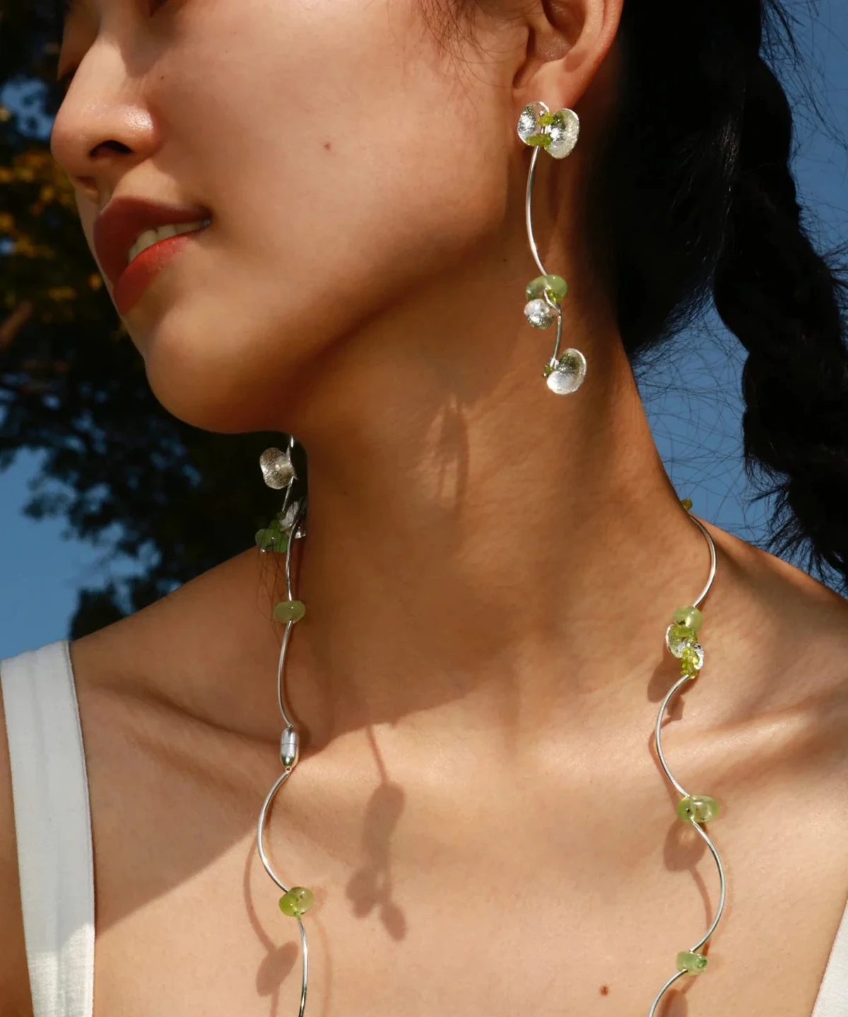 Model wearing Lazesoul’s Prelude Summer Peridot Earrings and matching necklace, handcrafted in sterling silver with natural green prehnite and peridot gemstones.