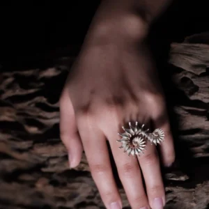 The Spiral Ring embodies modern artistry, seamlessly merging elegance with craftsmanship. Handmade in S925 sterling silver, this design ring features a sculptural spiral motif, creating a striking visual flow. The close-up image captures the ring’s refined details, worn gracefully on the hand, with a natural wooden texture enhancing its organic aesthetic. A statement piece designed for those who appreciate timeless sophistication and intricate design.