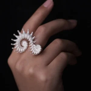 A close-up of a hand adorned with a Spiral Ring, crafted in S925 sterling silver, showcasing its sculptural and artistic design. The fluid, intertwined curves wrap elegantly around two fingers, creating a bold yet sophisticated statement.