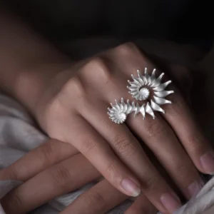 A close-up of a hand wearing a Spiral Ring, crafted from S925 sterling silver. The sculptural design features elegant curves that evoke movement and fluidity, making this design ring a striking statement piece. The polished finish highlights its artistry, seamlessly blending contemporary minimalism with handmade craftsmanship.