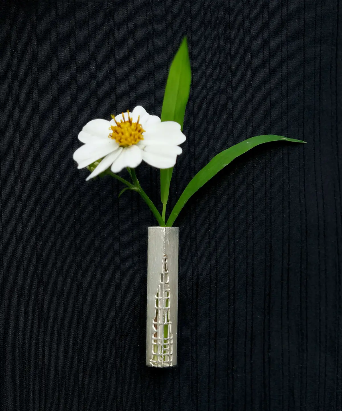 Handmade 925 sterling silver brooch featuring an intricately crafted silver frame, displayed alongside a fresh white flower with a yellow center.
