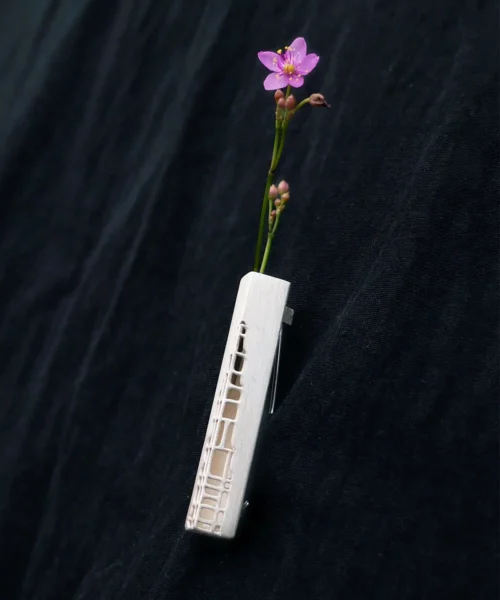 Handmade 925 Sterling Silver Brooch featuring a nature-inspired sculptural design. Crafted from high-quality sterling silver, this intricately detailed brooch showcases organic, flowing contours accented with a delicate purple flower motif. Set against dark fabric, the elegant craftsmanship highlights the timeless aesthetic of this artisan jewelry piece.