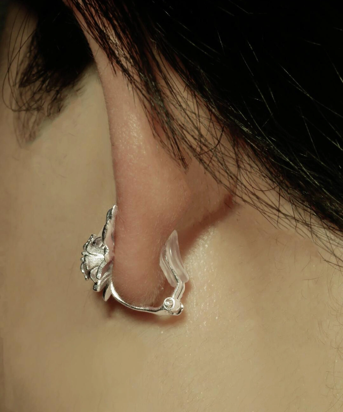 Close-up of ear wearing Lazesoul’s Lily Earrings-S925 Sterling Silver Ear Cuff, featuring delicate lily design and shimmering lab-created sapphire—nature-inspired handmade jewelry.