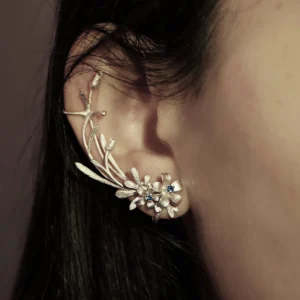 Close-up of ear wearing Lazesoul's Lily Earrings-S925 Sterling Silver Ear Cuff, featuring delicate lily-inspired floral motifs and lab-created sapphire accents; elegant handmade jewelry in natural style.