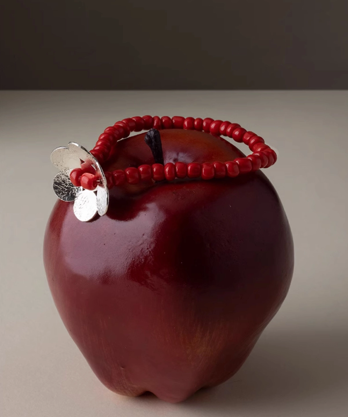 Lazesoul S925 sterling silver beaded ring bracelet with red glaze beads and little flower charm, wrapped around a red apple stem. Handmade jewelry highlighting natural elegance, perfect for nature lovers and artisanal style enthusiasts.