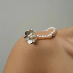 Close-up of Lazesoul’s Little Flower Beaded Bracelet in S925 Sterling Silver, with natural freshwater pearls and floral silver accents, styled on a shoulder; a handmade beaded ring bracelet combining elegance with artisanal craftsmanship.