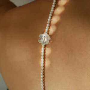 Back view of a woman wearing Lazesoul’s S925 Sterling Silver Little Flower Beaded Necklace with natural freshwater pearls. Delicate silver flower pendant accents the handcrafted design, ideal for elegant, nature-inspired styling.