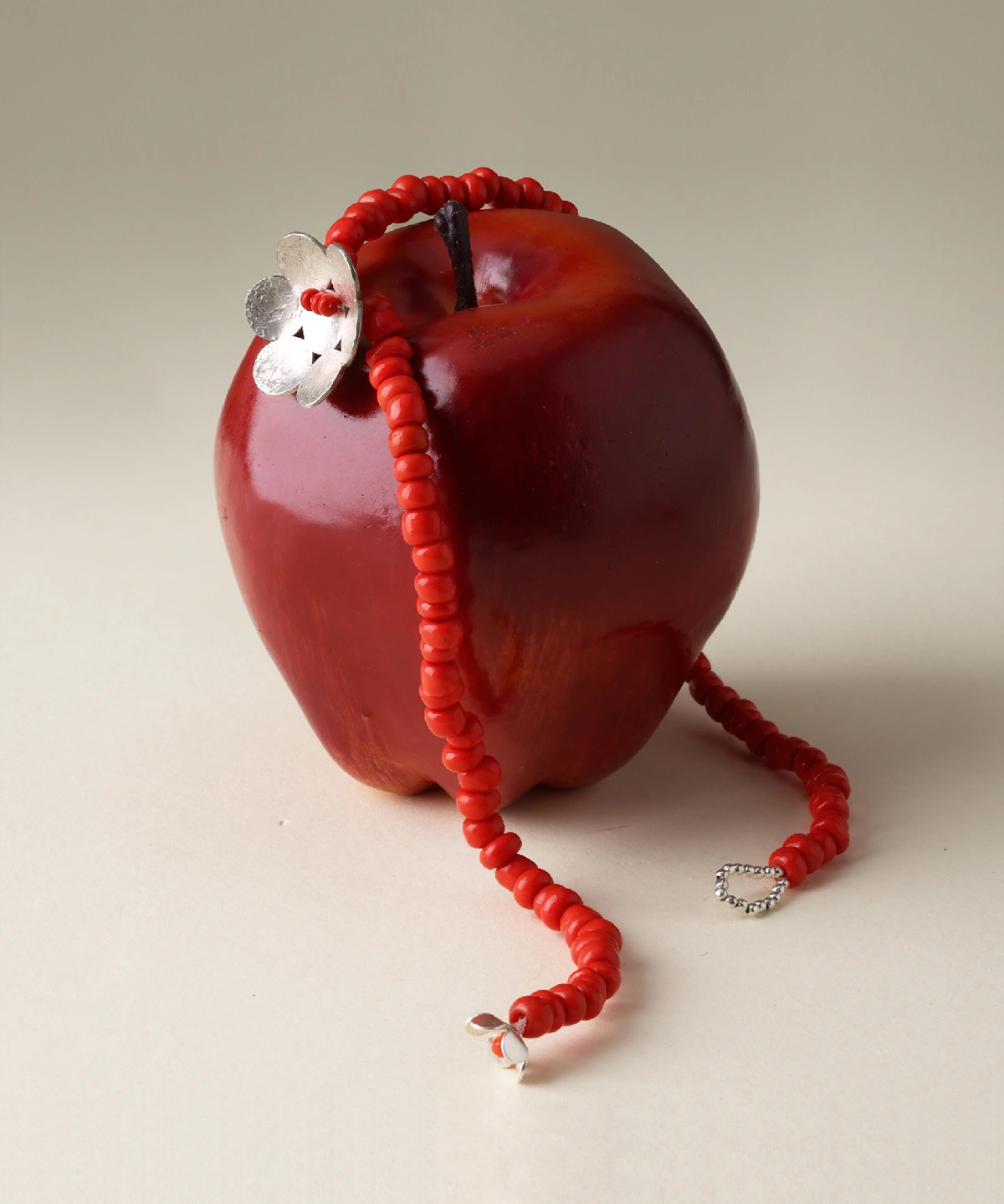 S925 sterling silver Little Flower Beaded Necklace displayed on a red apple; features handmade red glaze beads and floral charm, highlighting Lazesoul’s natural jewelry craftsmanship.